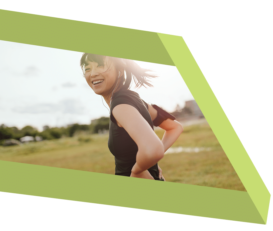 Smiling young woman jogging through field