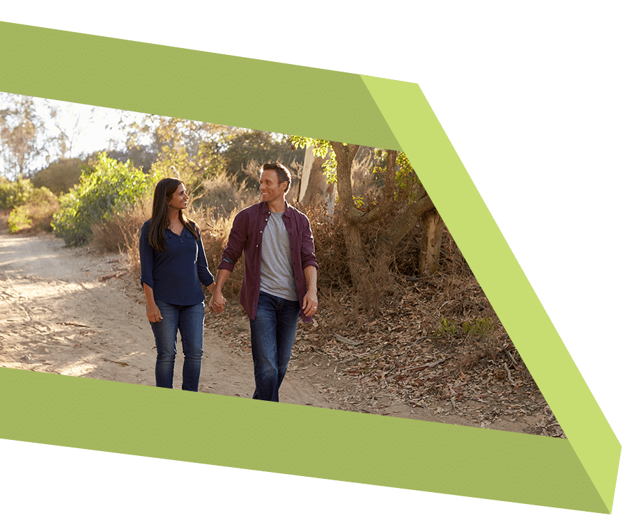 Couple holding hands walking on a nature trail